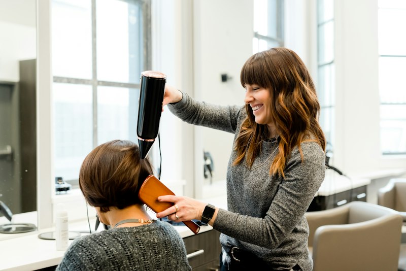 Photo d'illustration : brushing au sèche-cheveux en salon
