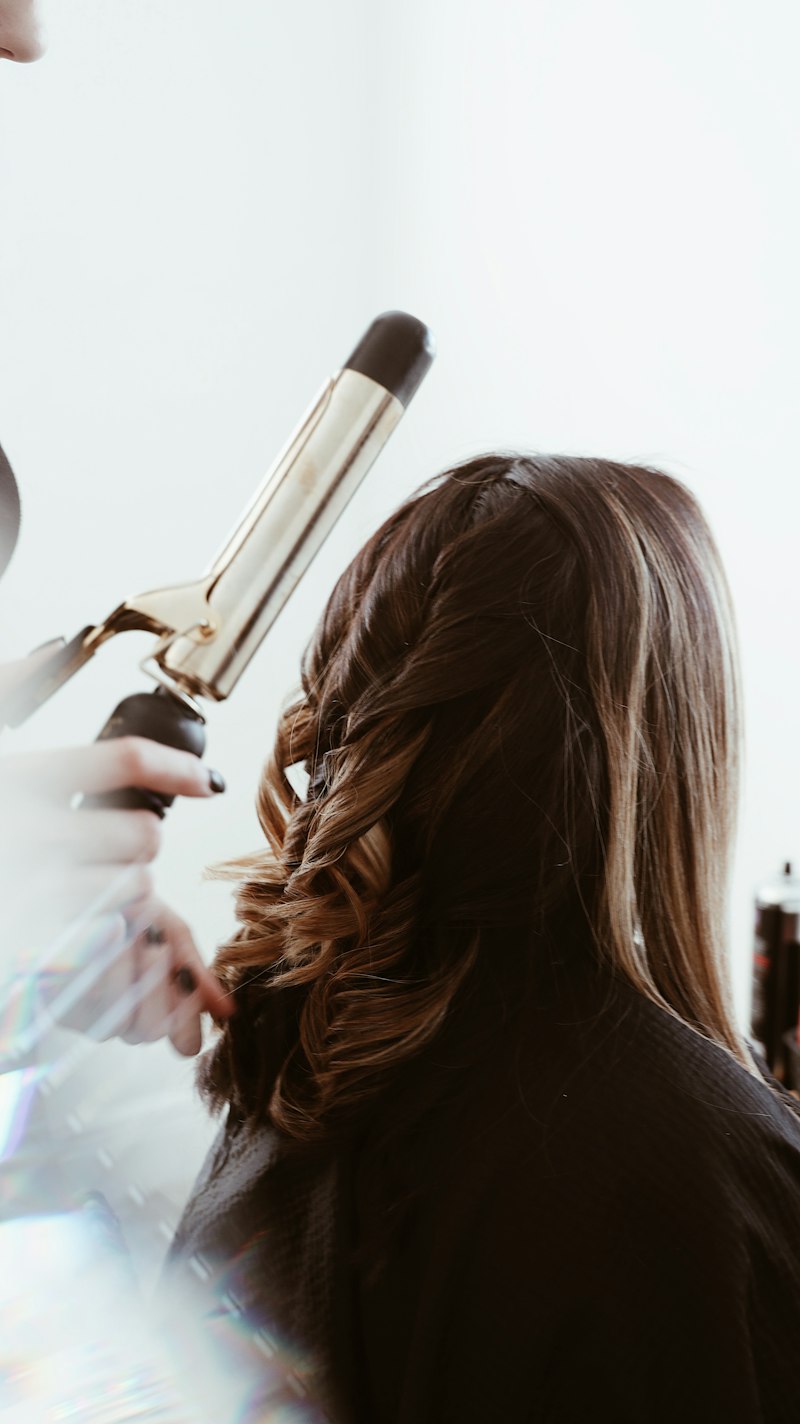 Photo d'illustration : mise en boucles au fer sur chevelure brune